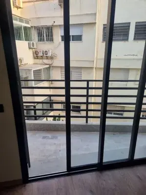 an open glass door with a view of a building at charmant studio en plein cœur de maarif in Casablanca