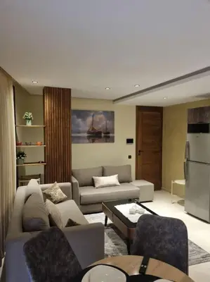 a living room with a couch and a refrigerator at charmant studio en plein cœur de maarif in Casablanca