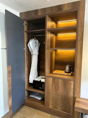 a closet with wooden shelves and a shirt hanging in it at Executive Boutique Hotel Rabat in Rabat