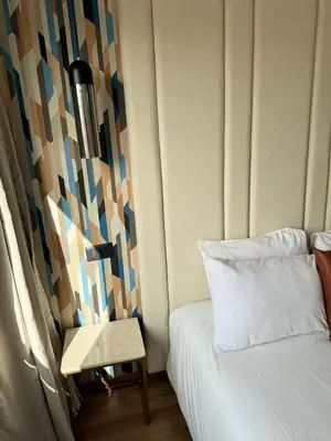 a bedroom with a bed and a table with a lamp at APPARTEMENT LUXUEUX 29 neuf avec terrasse in Casablanca