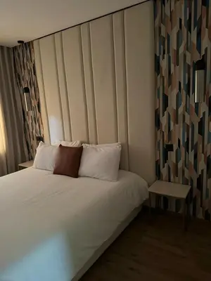 a bedroom with a white bed and a side table at APPARTEMENT LUXUEUX 29 neuf avec terrasse in Casablanca