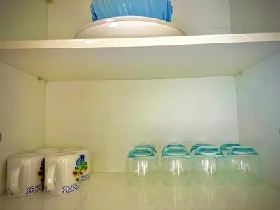 a row of clear glasses sitting on a shelf at Appartement lumineux vue sur piscine, 4 min de la Plage in Bouznika