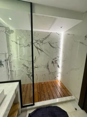 a bathroom with a marble shower with a wooden floor at Classy presidential apartment in Casablanca