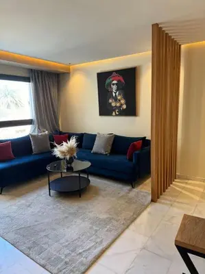 a living room with a blue couch and a table at Classy presidential apartment in Casablanca