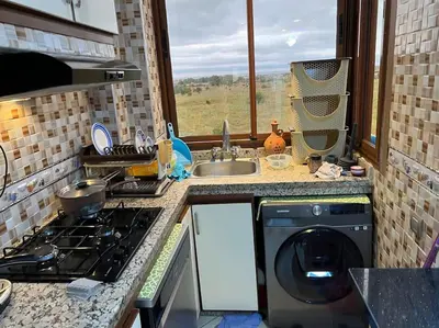a kitchen with a washing machine and a sink at Confort repos et belle vue mer in Bouznika