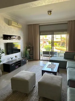 a living room with a couch and a tv at Appartement haut standing près de la Plage in Skhirat