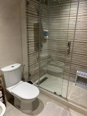 a bathroom with a toilet and a glass shower at Appartement haut standing près de la Plage in Skhirat