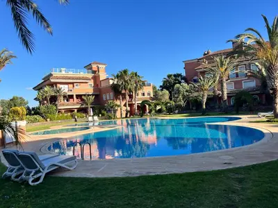 a swimming pool in front of a building at Appartement de H standing in Bouznika