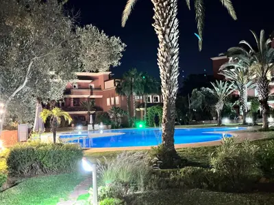 a resort with a swimming pool at night at Appartement de H standing in Bouznika