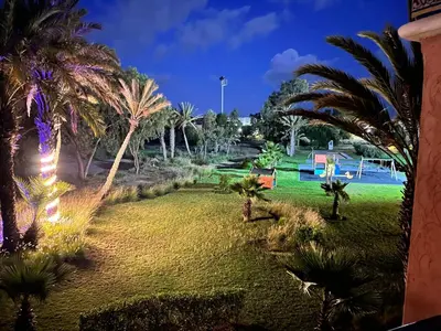 a park with palm trees and a playground at Appartement de H standing in Bouznika