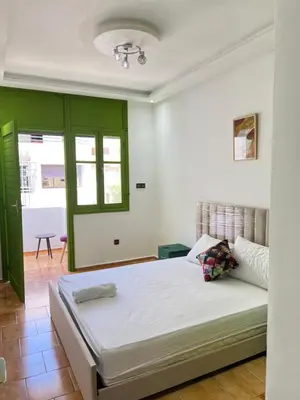 a bedroom with a bed and a green wall at Grenn appt in Rabat