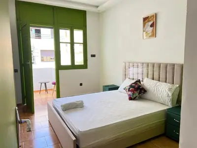 a bedroom with a large bed with a green door at Grenn appt in Rabat