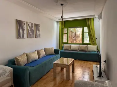 a living room with two blue couches and a table at Grenn appt in Rabat