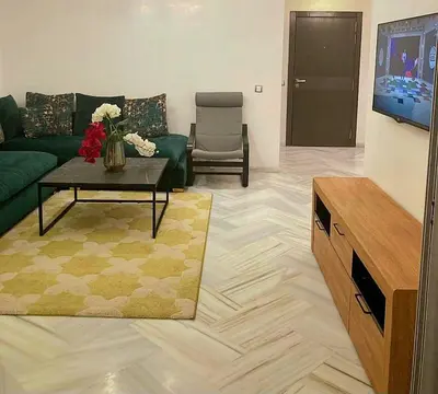 a living room with a couch and a table and a tv at La siesta beach resort two bedroom appartement in Mohammedia