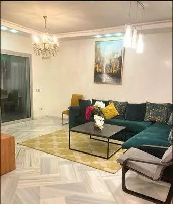 a living room with a green couch and a coffee table at La siesta beach resort two bedroom appartement in Mohammedia