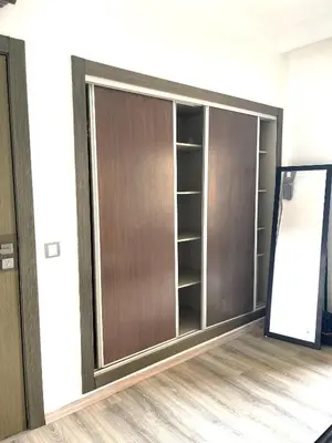 a closet with wooden doors in a room at La siesta beach resort two bedroom appartement in Mohammedia