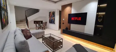 a living room with a couch and a tv on the wall at Duplex One Hill Ville Verte in Casablanca