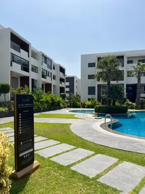 a sign in the grass in front of a building at Duplex One Hill Ville Verte in Casablanca