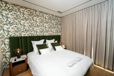 a bedroom with a large white bed with a green headboard at Le studio in Casablanca