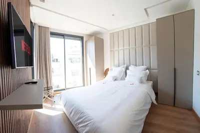 a bedroom with a white bed and a large window at Magnifique Studio neuf in Casablanca