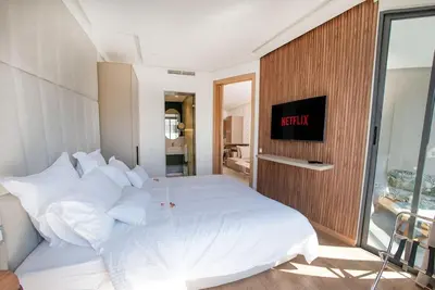 a bedroom with a white bed with a clock on the wall at Magnifique Studio neuf in Casablanca