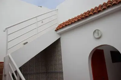 a white building with a staircase next to a door at Maison d'hôte sur la Plage de Bouznika in Bouznika