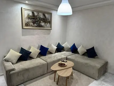 a living room with a couch with blue pillows at Studio Appartement MIRAMAR in Mohammedia