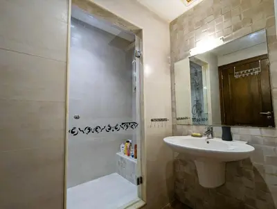 a bathroom with a sink and a shower at Appartement de plain-pied, piscine et mer in Bouznika