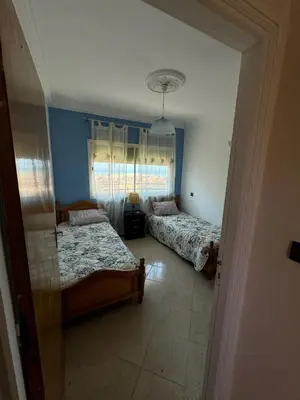 a bedroom with two beds and a window at Triplex à 5 min de la plage ! in Temara