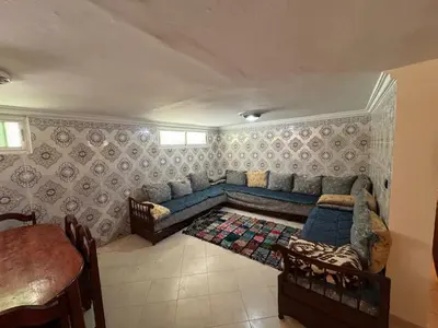 a living room with a blue couch and a table at Triplex à 5 min de la plage ! in Temara