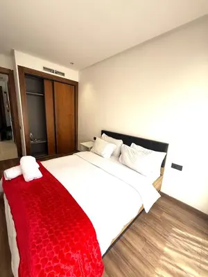 a bedroom with a large bed with a red blanket at Cozy princesse living maarif in Casablanca
