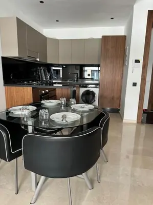 a kitchen with a black table and black chairs at Cozy princesse living maarif in Casablanca
