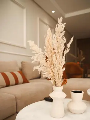 a white vase with flowers on a table in a living room at Sancy Luxury rez de jardin avec piscine privée in Casablanca