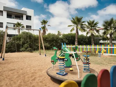 a playground in the sand near a building at Sancy Luxury rez de jardin avec piscine privée in Casablanca