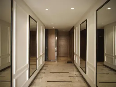 a hallway with wooden doors and a tile floor at Sancy Luxury rez de jardin avec piscine privée in Casablanca