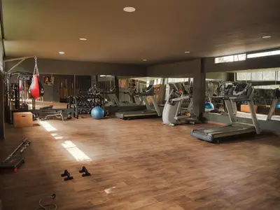 a gym with several treadmills and machines at Sancy Luxury rez de jardin avec piscine privée in Casablanca