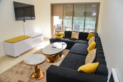 a living room with a couch and a tv at Le Joyau du Parc in Mohammedia