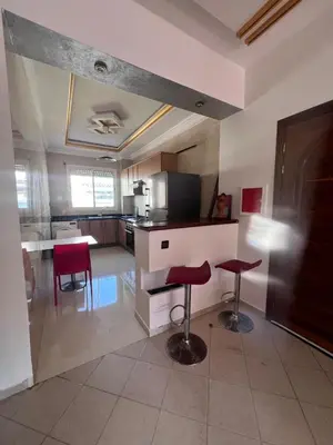 a kitchen with two stools and a table in a room at MOHAMMEDIA Rico Flores in Mohammedia