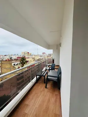a balcony with chairs and a view of a city at Appartement spacieux - BD Anfa in Casablanca