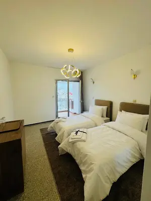 a row of four beds in a room with a chandelier at Appartement spacieux - BD Anfa in Casablanca