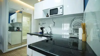 a kitchen with white cabinets and a microwave at Bleu Studio in Rabat