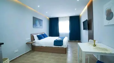 a bedroom with a bed and a table and a sink at Bleu Studio in Rabat