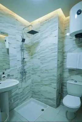 a bathroom with a shower and a toilet and a sink at Bleu Studio in Rabat