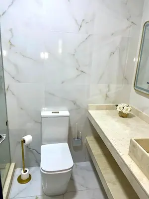 a white bathroom with a toilet and a sink at The hidden oasis, steps from the beach and pool in Mohammedia