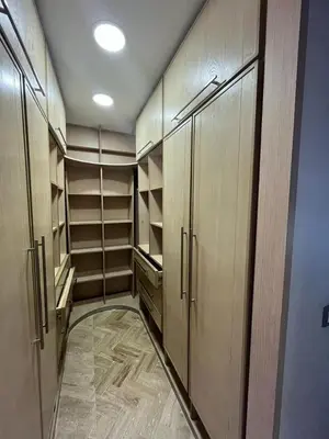 a walk in closet with wooden cabinets and shelves at Elégance et confort au coeur de Casablanca in Casablanca