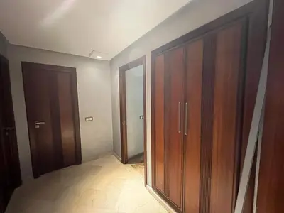 an empty room with wooden cabinets and a hallway at Elégance et confort au coeur de Casablanca in Casablanca