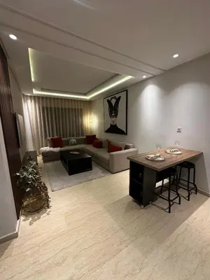 a living room with a couch and a table at Beau studio au cœur du parc in Mohammedia