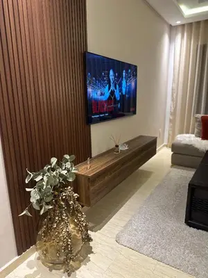 a living room with a tv and a vase with flowers at Beau studio au cœur du parc in Mohammedia