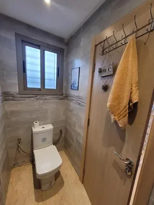 a bathroom with a toilet and a window at Charmante villa vue sur la mer in Tamaris