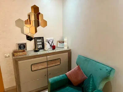 a living room with a green couch and a mirror at Zen & Welcoming CFC - Garage & Tramway in Casablanca